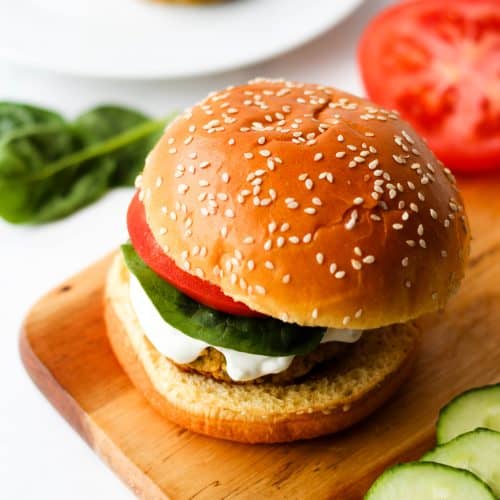 greek chickpea burger on a bun with lettuce, tomato and tzatziki