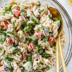 A healthy tuna pasta salad made with rotini pasta, red peppers, cucumber, celery, peas, tuna and a creamy greek yogurt dill dressing.