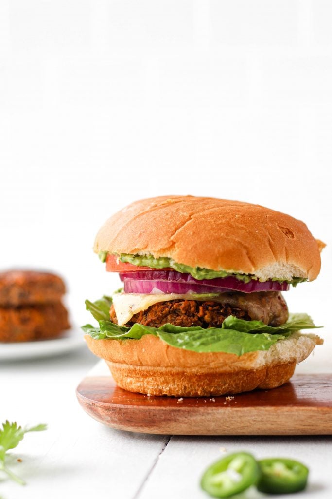 This spicy bean burger recipe is nutritious, delicious, and easy to make. Paired with homemade cilantro avocado sauce, this might just be the most flavourful vegetarian burger you'll ever try!