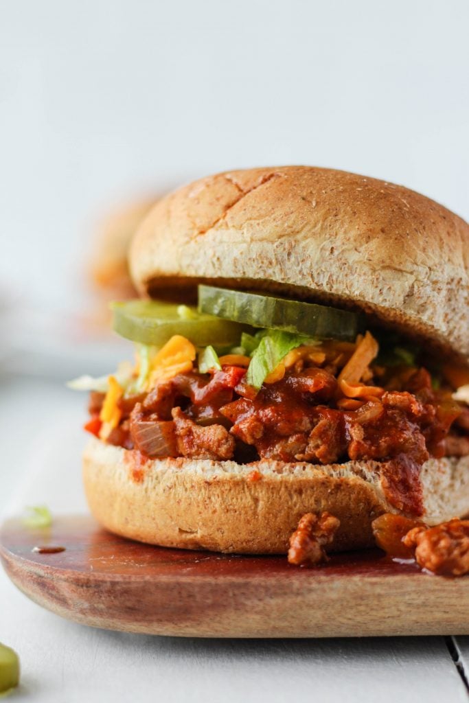 Ground chicken sloppy joes on a bun with cheese, lettuce and pickles.
