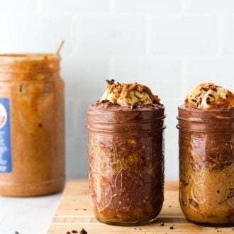 jars of chocolate peanut butter overnight oats on a wood serving board