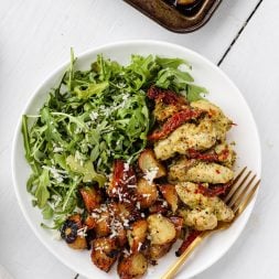 chicken potatoes and arugula salad on a plate