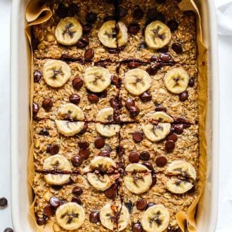 pan of baked oatmeal with banana slices and chocolate chips sliced into eight pieces