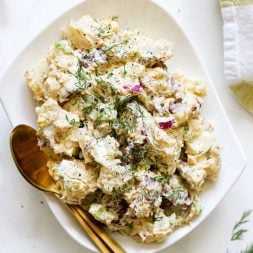 creamy potato salad on a plate with two spoons