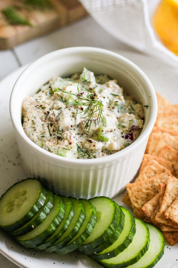 salmon salad made with canned salmon in a dish plated with crackers and cucumber slices