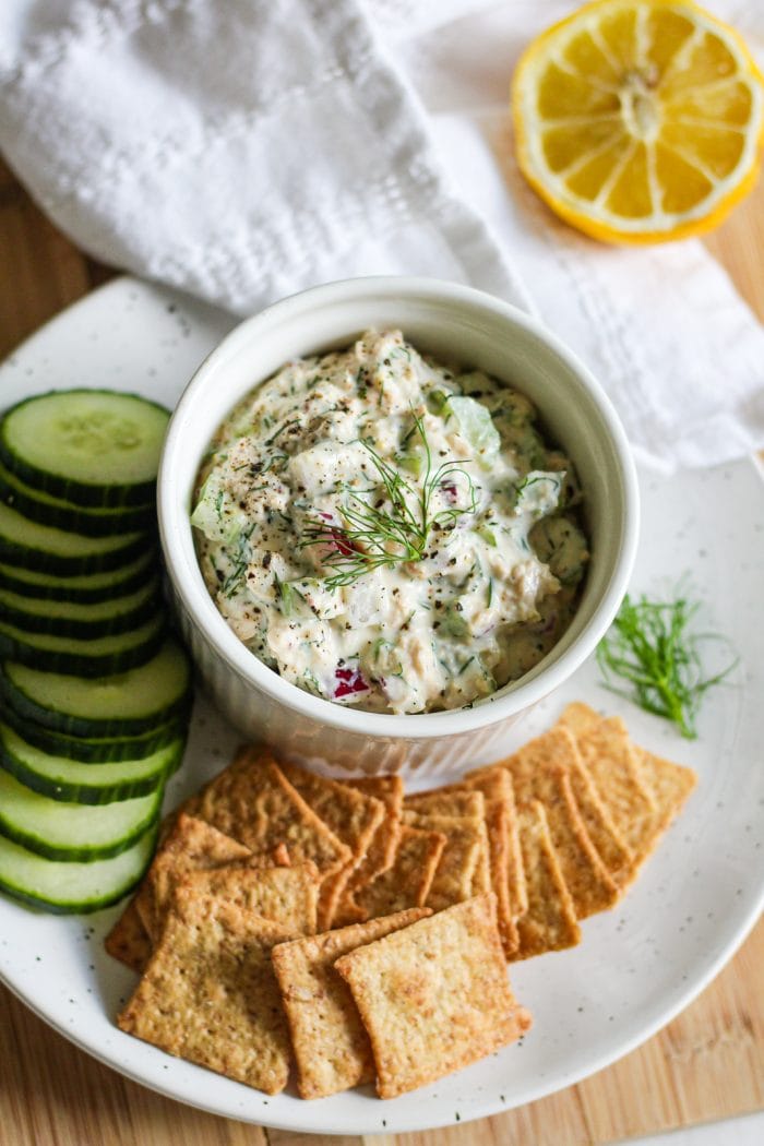 salmon salad made with canned salmon in a dish plated with crackers and cucumber slices