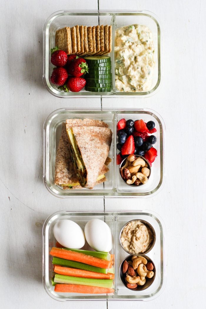 three lunch boxes with lunches made with eggs