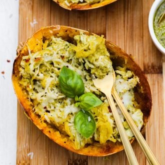 half of a cooked spaghetti squash stuffed with pesto and chicken