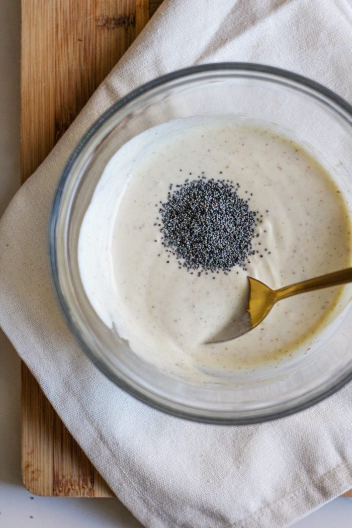 Dressing mixture in a bowl with poppyseeds.
