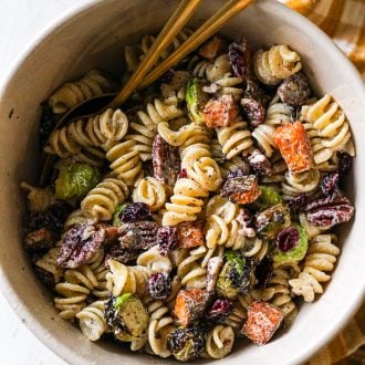 bowl of pasta salad with roasted vegetables, pecans, and dried cranberries