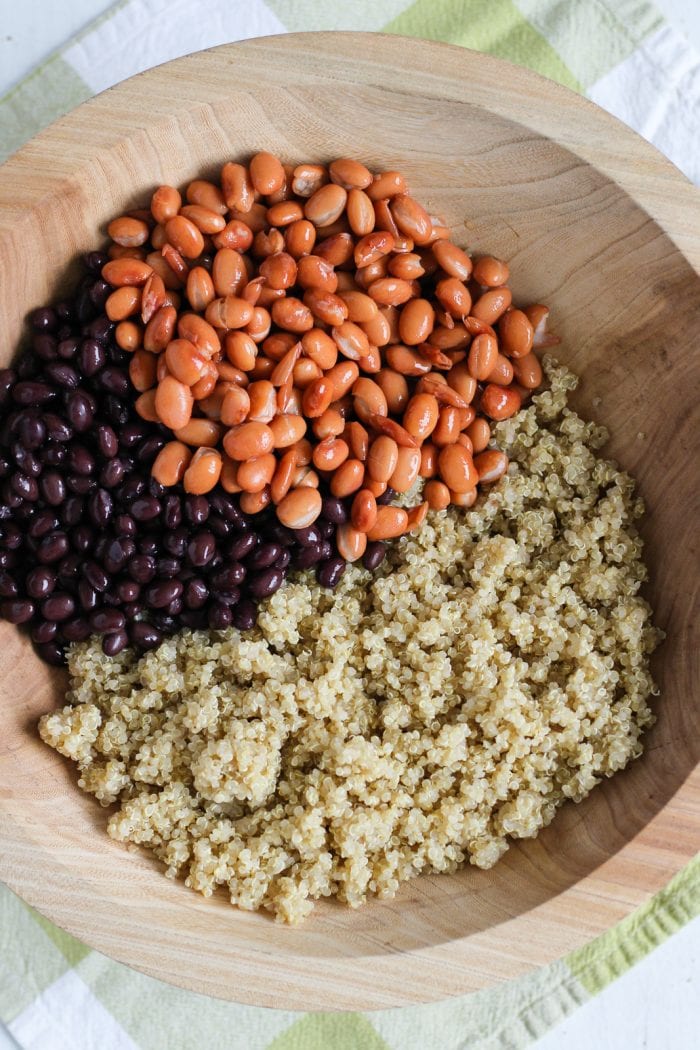 large salad bowl with cooked quinoa, black beans, and pinto beans