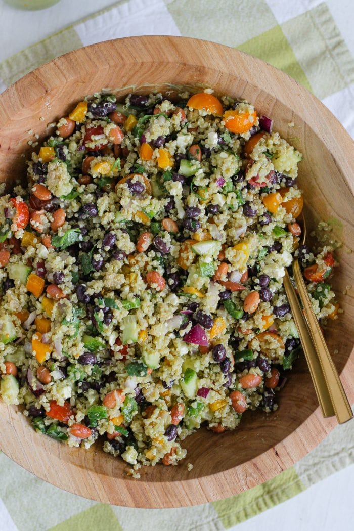 quinoa bean salad tossed with avocado dressing in a large salad bowl