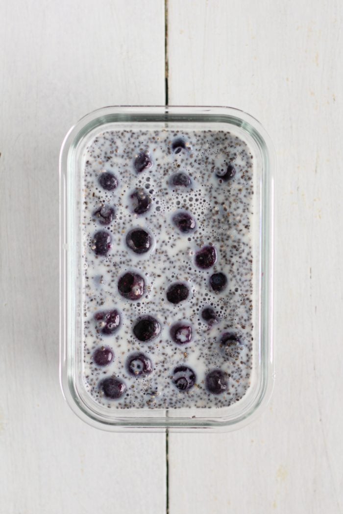 chia seeds, milk, maple syrup, vanilla extract, and blueberries in a meal prep container