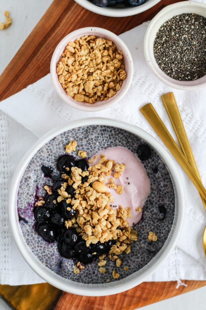 bowl of chia seed pudding topped with berries, yogurt and granola