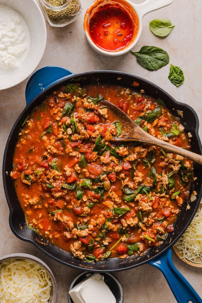 pan of cooked ground turkey mixed with spinach and pasta sauce