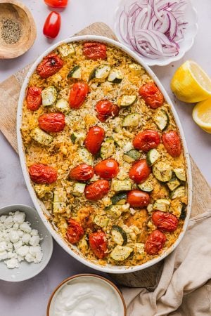 freshly baked chicken and rice casserole with zucchini, grape tomatoes, and feta cheese
